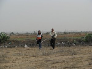 Farmer sows seeds while ISM volunteer walks alongside him. Farmer sows seeds while ISM volunteer walks alongside him.