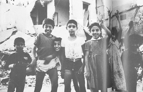 Children standing in destroyed Sabra and Shatila camps raise the victory salute, Beirut, September 1982